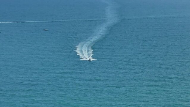 Small motorboat sailing fast on ocean waves with ripple water surface. Sailboat in motion on ocean in Florida