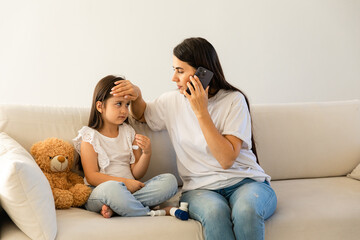 Closeup portrait of mother calling a doctor because of her little daughters illness, calls an ambulance or a pediatrician, asking about treatment, bronchitis or cold.