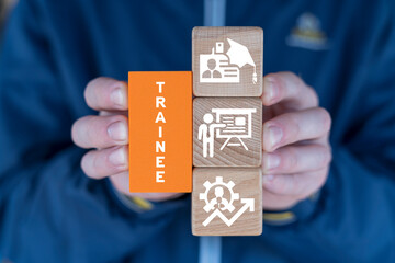 Man holding colorful blocks sees word: TRAINEE. Trainee concept for internship training and learning program. Apprenticeship of intern, apprentice, training, mentor, support, cooperation, and improve.