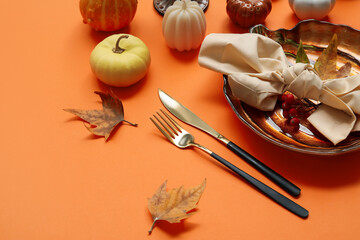 Autumn table setting with leaves on orange background