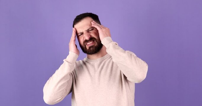 Frustrated bearded man touch temples forehead headache isolated on purple background. Headache. Head pain. 
