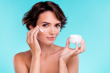 Photo of stunning gorgeous gentle lady applying cream on facial cheeks for soft silky skin over blue background