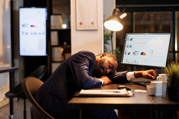 Tired executive worker sleeping on desk in startup office, workaholic employee falling asleep...