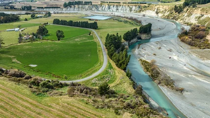Foto op Canvas The blue water of the Awatere river flowing through agricultural farmland in a rural valley © Stewart