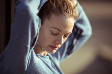 Attractive young woman tying hair before a jog in the city