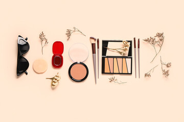 Composition with makeup products, accessories and dry twigs on beige background
