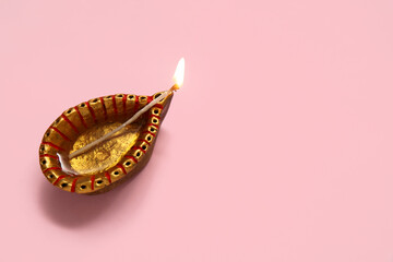 Diya lamp on pink background. Divaly celebration