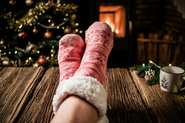 woman wearing pink wool winter socks in front of fireplace