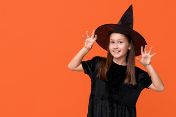 Cute little girl dressed for Halloween as witch on orange background