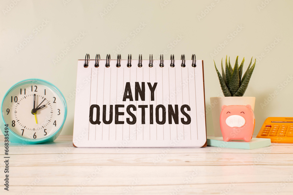 Poster any questions text written on a notebook on the wooden background