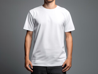 Man wearing a mock up t-shirt design while standing in front of a grey background