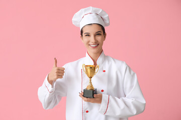 Female chef with gold cup showing thumb-up on pink background