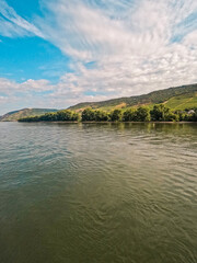 Fototapeta premium Scenic Lush Green Hills, Forest, and Agricultural Fields on The Rhine River. Located in Niederheimbach - a small German village in the Rhineland-Palatinate region of southwestern Germany