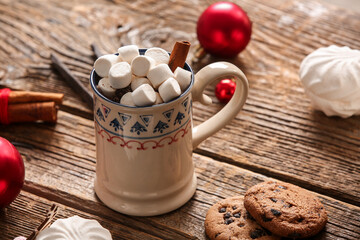 Cup of hot cocoa with marshmallows, cinnamon and sweet cookies on wooden background