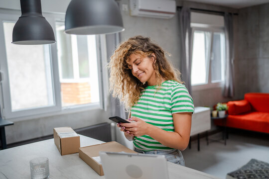 one woman checking box of received package or product at home