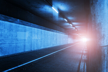 Horror tunnel background. Dark pavement tunnel with bright light at the end. Scary walkway under...