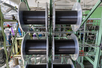 Textile industry with knitting machines in factory. Textile industry with a loom on the production of textile tape.