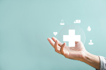 A hand holds a plus icon for medical care, indicating advantages. Health insurance health concept featuring access to welfare health and room for content.