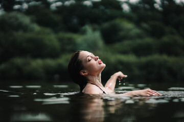 beautiful woman swims in the water of a lake river, swimming lessons. - obrazy, fototapety, plakaty