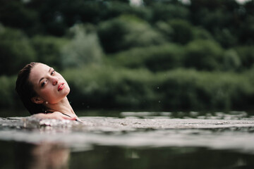 beautiful woman swims in the water of a lake river, swimming lessons.