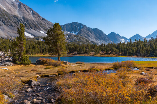 Hiking in Little Lakes Valley in the Eastern Sierra Nevada Mountains outside of Bishop, California. Alpine lakes, fall leaf colors, snow capped mountains and evergreen trees combine to make a pictures