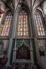 Colorful stained glass windows in Romanesque three-nave columned basilica. Minster (Münster...