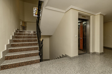 Landing of an urban residential building with polished gray granite floors, stairs of the same...