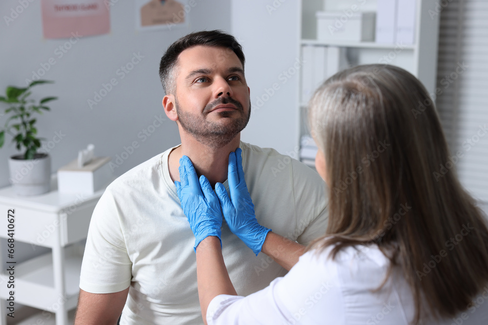 Poster Endocrinologist examining thyroid gland of patient at hospital