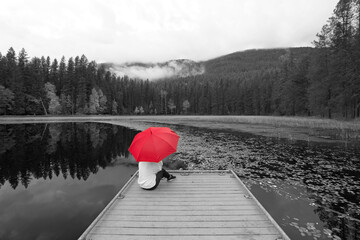 Concept of B&W photo with woman holding red umbrella.
