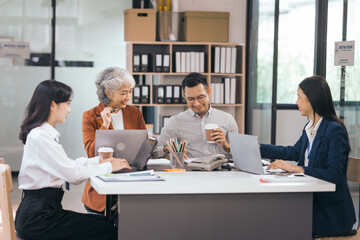 Four asian people in an office, working together on laptops, discussing tasks. annual gathering where attendees share and discuss opinions, presentation teamwork group meeting laptop in boardroom