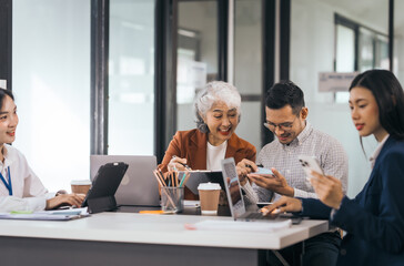 Four asian people in an office, working together on laptops, discussing tasks. annual gathering where attendees share and discuss opinions, presentation teamwork group meeting laptop in boardroom