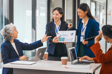 Four asian people in an office, working together on laptops, discussing tasks. annual gathering where attendees share and discuss opinions, presentation teamwork group meeting laptop in boardroom