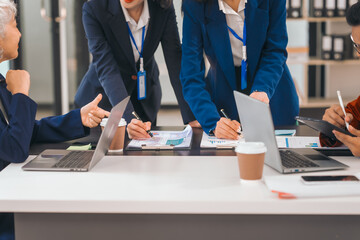 Four asian people in an office, working together on laptops, discussing tasks. annual gathering where attendees share and discuss opinions, presentation teamwork group meeting laptop in boardroom