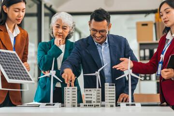 Group of asian business people meeting boardroom clean energy solutions. discussing solar panels, wind turbines, suggesting ideas for sustainable city. mature teaching, grey hair people, young adult