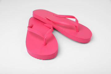 Stylish pink flip flops on white background