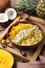 Tasty smoothie bowl with fresh fruits served on wooden table