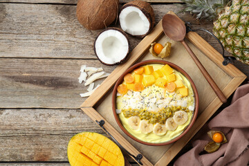 Tasty smoothie bowl with fresh fruits served on wooden table, flat lay. Space for text