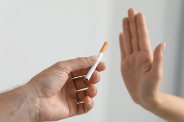 Stop smoking concept. Woman refusing cigarette on light background, closeup