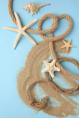 Fototapeta na wymiar Beautiful starfishes, sea shell, rope and sand on light blue background, flat lay