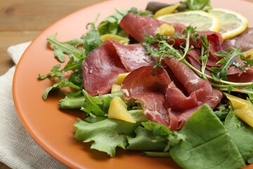 Delicious bresaola salad on table, closeup view