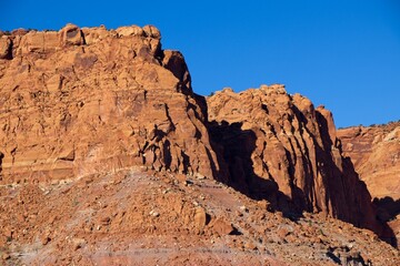 Fototapeta premium A drive through the northern edge of Capitol Reef National Park brings you along a winding surrounded by steep, beautiful red rock walls
