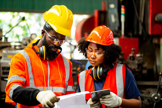 Two african worker check status task  in production