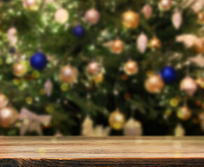 Wooden table near beautifully decorated Christmas tree. Space for design