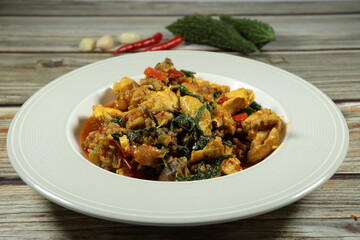 Traditional fried and spicy chopped chicken mixed with chilly, basil, garlic and pepper serving in the plate. Famous local hot menu in Asian restaurant.