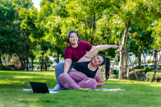 Fat  woman overweight training doing yoga at the park happy  smiling women in yoga class exercising outdoors. the park in the morning