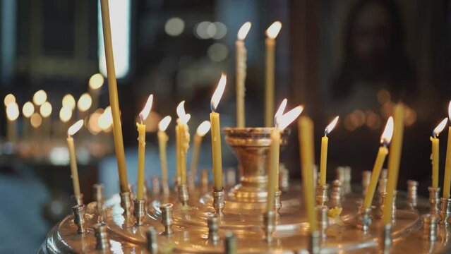 The theme of religion, faith and the Orthodox Church. A close-up of much waxed candles are burning in a candlestick. Burning candles in Orthodox Christian church.