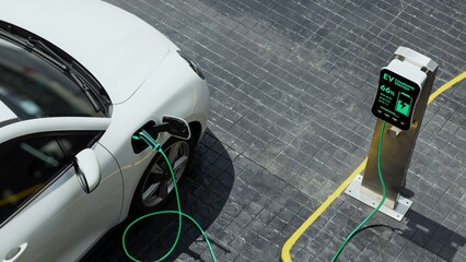 Aerial view electric car recharging battery from EV charging station at city center public car...