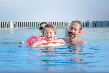 Happy family children in swimming pool .Funny kids playing outdoors. Summer vacation concept.