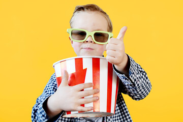 Cute fun kid baby boy 4 year old in red t-shirt holding bucket for popcorn