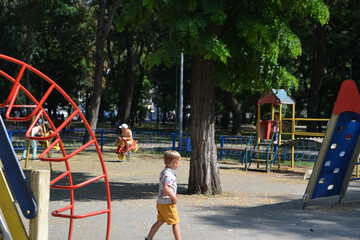 Little children run around and play in the playground.